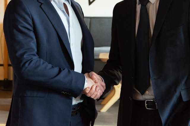 Two people sealing an agreement with a handshake